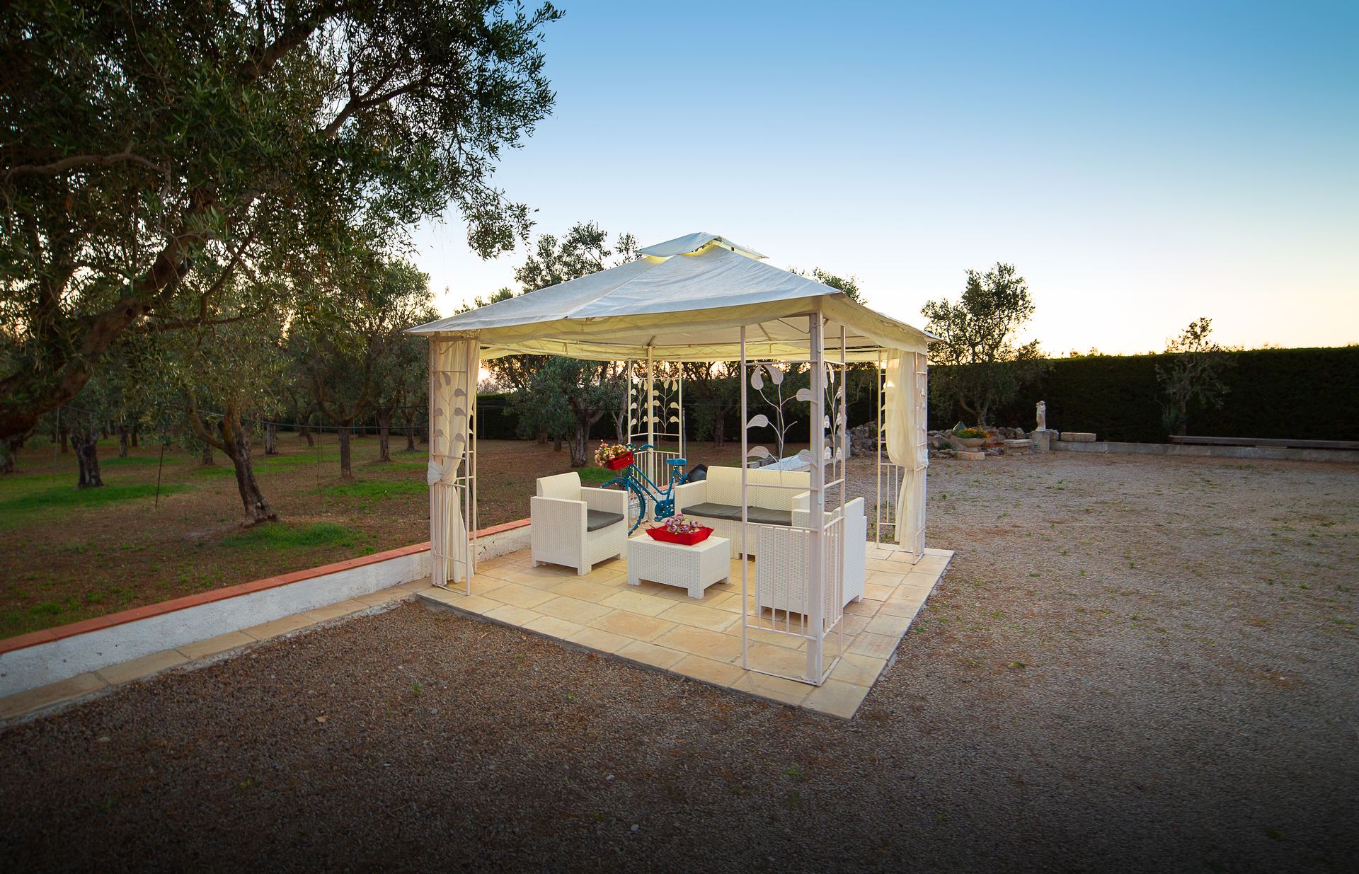 Gazebo con divani bianchi nell'oliveto