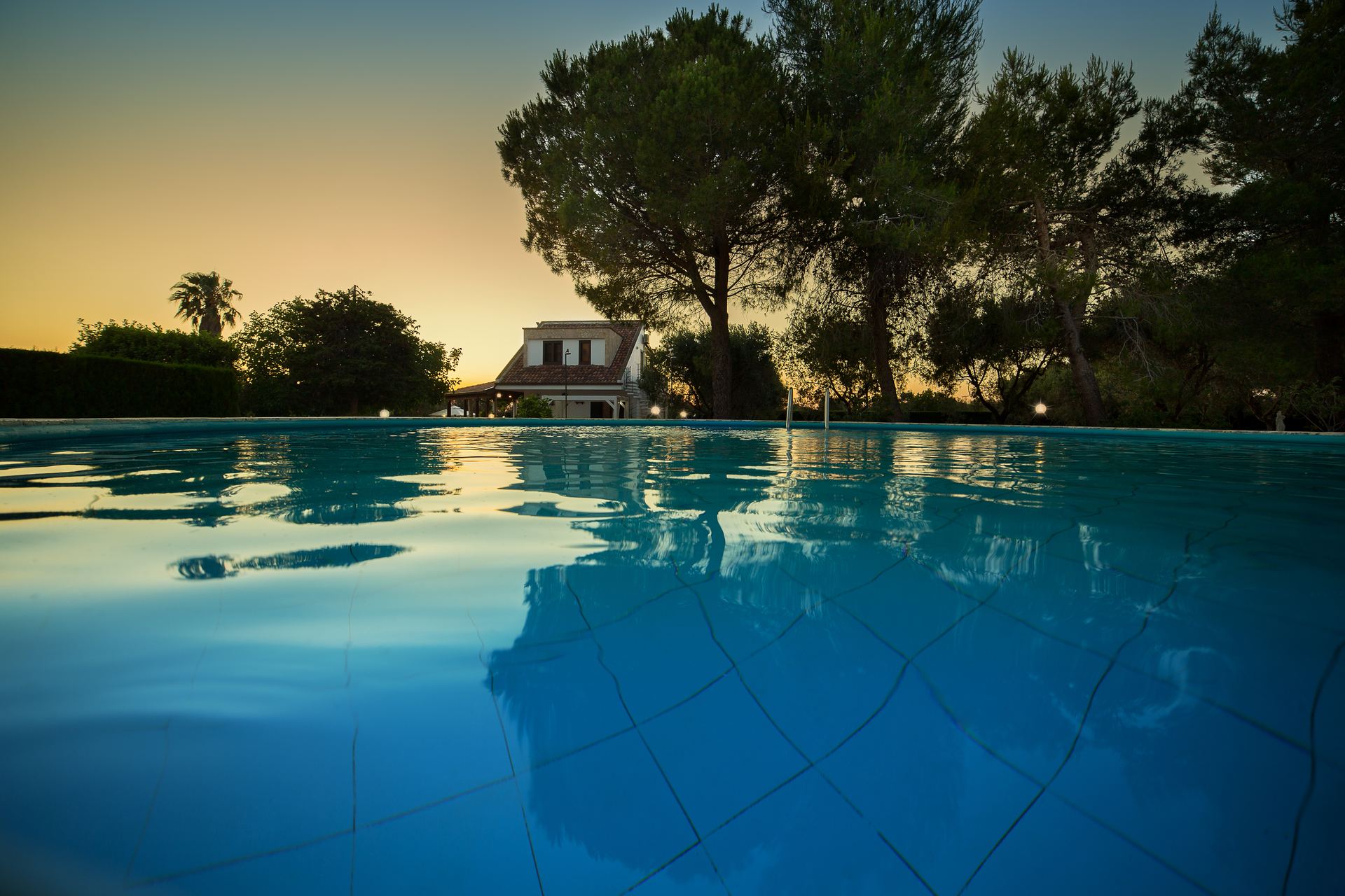 Piscina al tramonto — mosaico azzurro a livello dell'acqua