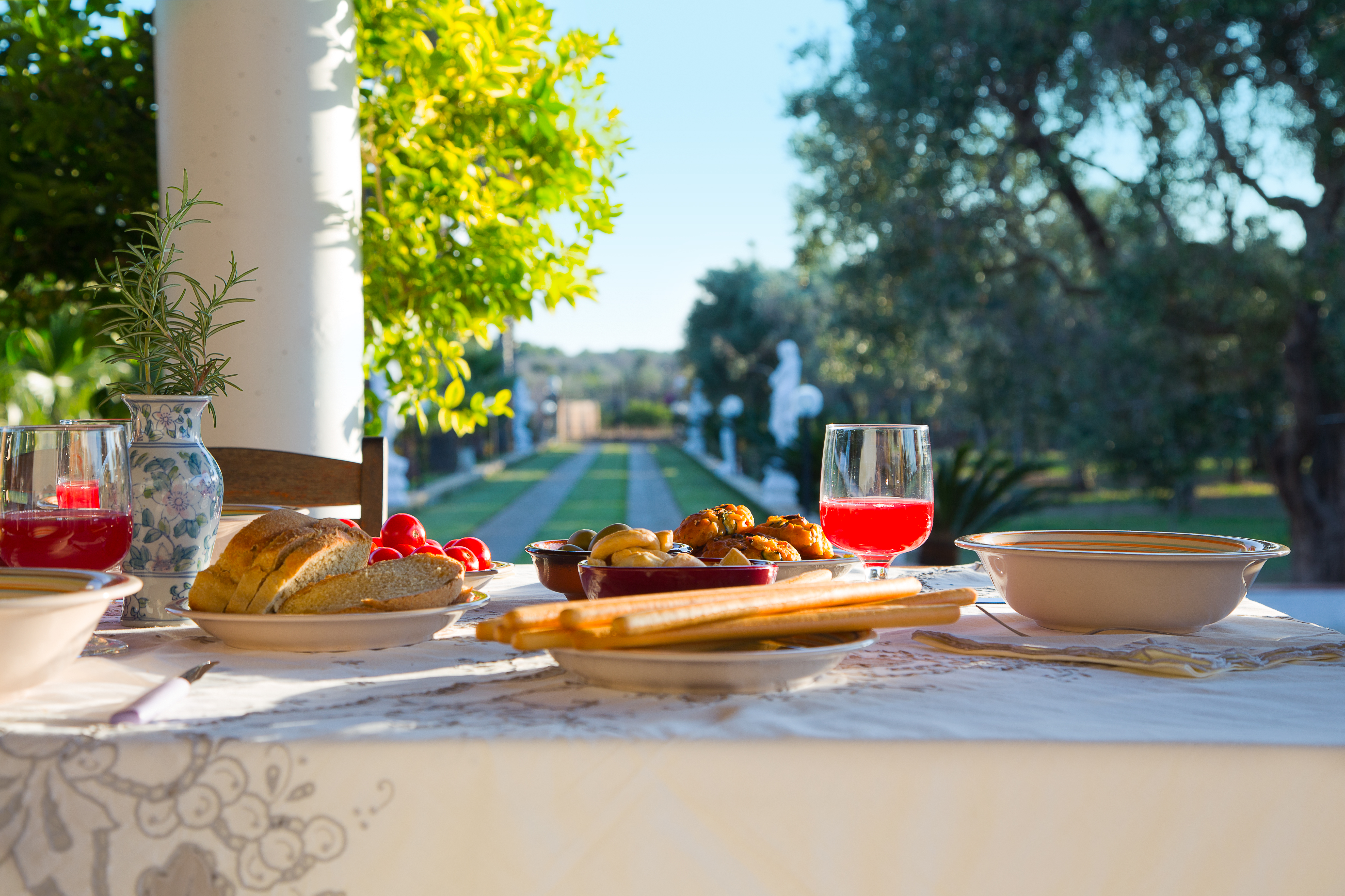 Antipasti pugliesi sul portico — viale con palme sullo sfondo