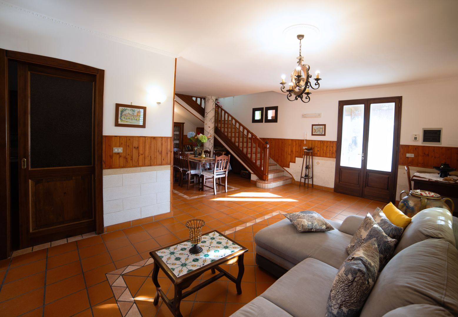 Ingresso Villa dei Sogni — scala in legno e lampadario in ferro battuto