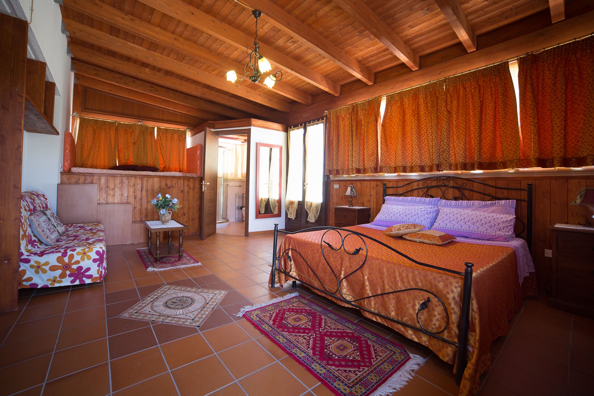 Suite Villa dei Sogni — travi a vista e letto in ferro battuto