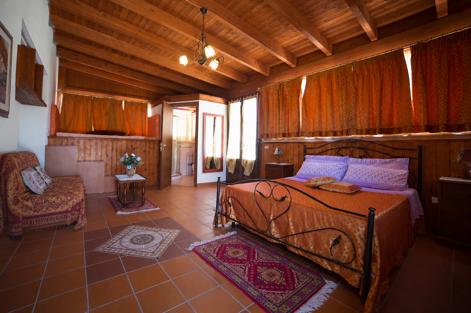 Suite Villa dei Sogni — travi a vista e letto in ferro battuto