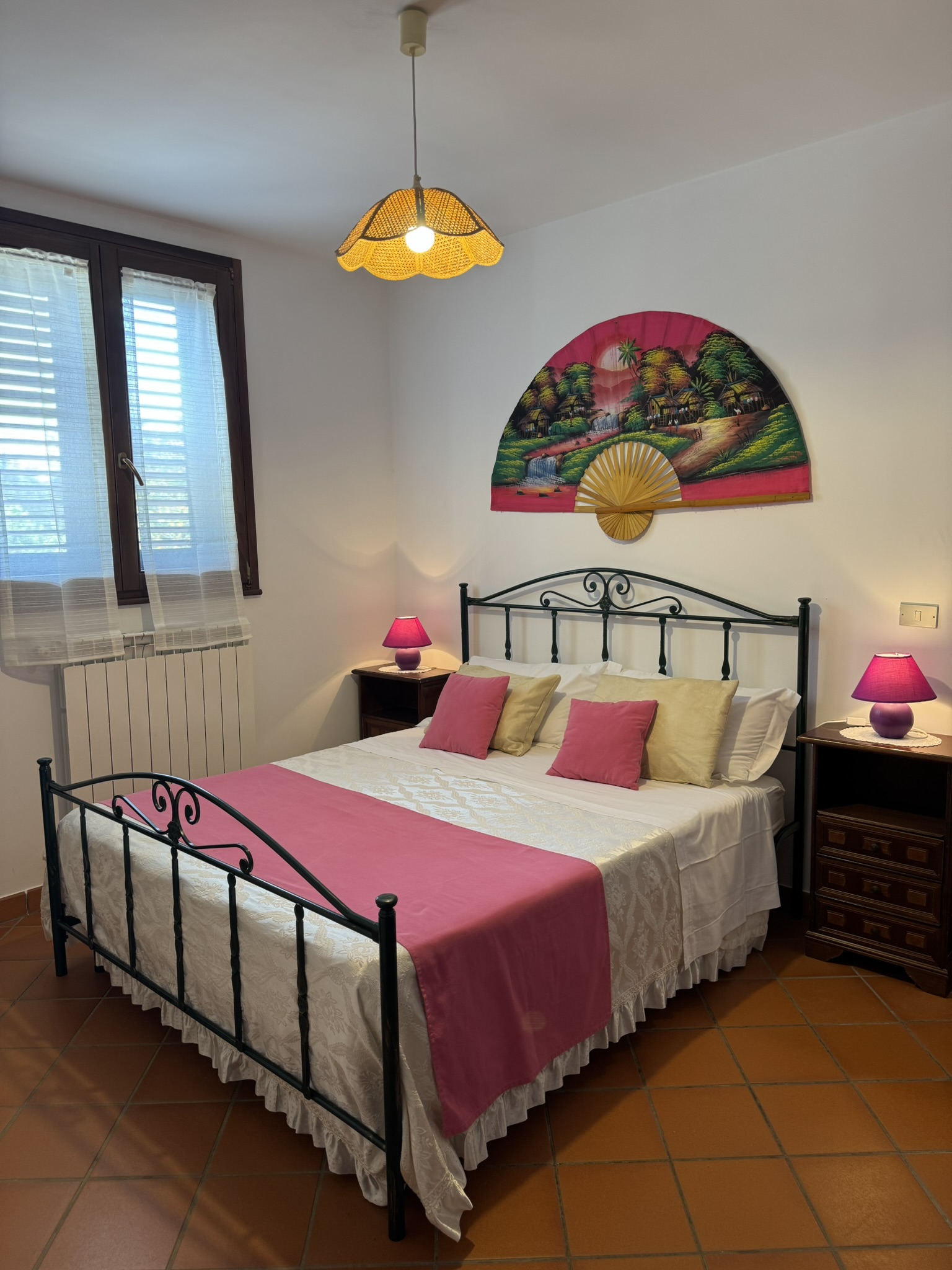 Camera del Melograno — letto in ferro battuto e ventaglio decorativo